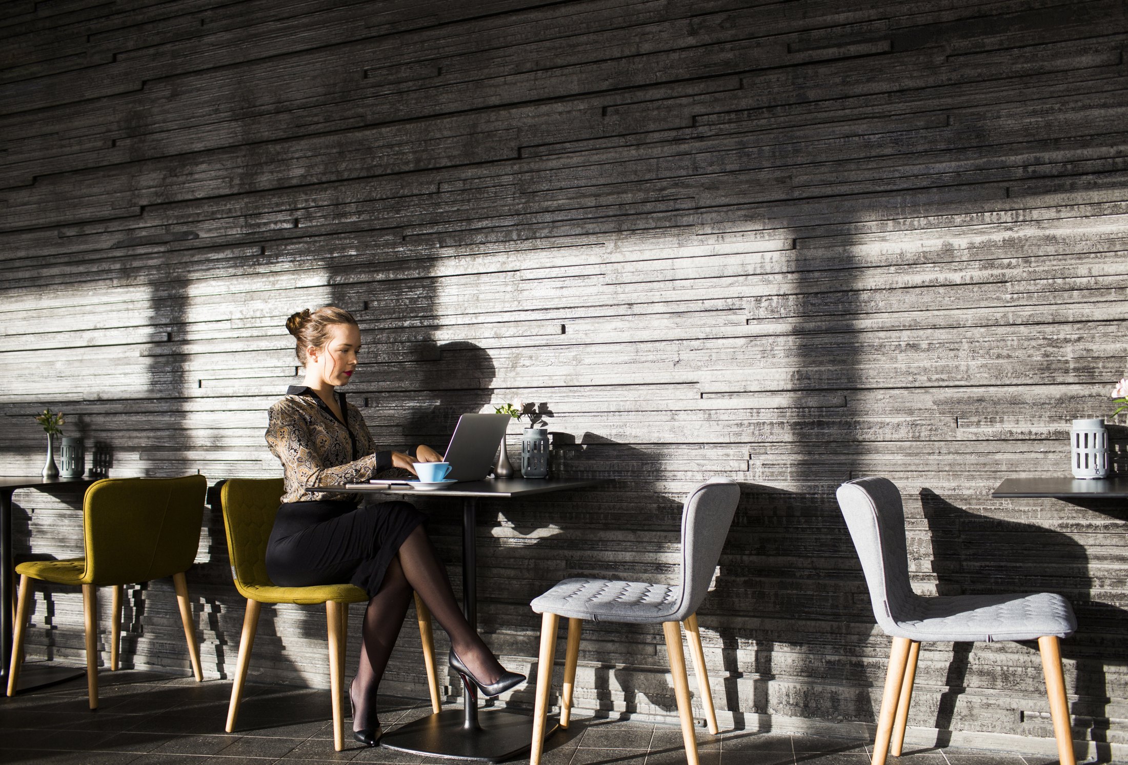 Kvinna arbetar med en laptop på ett café – illustrationsbild
